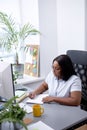 Black Office Woman Sitting At Desk Working On Laptop Taking Notes At Work Indoor