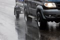 black offroad car with hindcarriage behind on wet asphalt road at rainy day Royalty Free Stock Photo