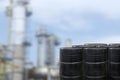 Black oil barrels against with Oil refinery blurred background