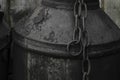 Black and oiled metal canister with the metal rusty chain in the countryside Royalty Free Stock Photo