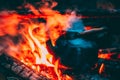 Old Retro Iron Camp Kettle Boiling Water On A Fire In Forest. Bright Flame Fire Of Bonfire At Dusk Night Royalty Free Stock Photo