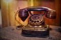 An old rotary phone on an old zinc suitcase, with a teak wood room divider background Royalty Free Stock Photo