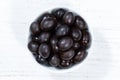 Black olives from above bowl on a wooden board Royalty Free Stock Photo