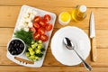 Black olives, feta cheese, dill, pieces of cucumbers, tomato on cutting board, spoon in bowl, bottle of vegetable oil, salt, knife Royalty Free Stock Photo