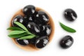 Black olives with leaves in wooden bowl isolated on a white background with full depth of field. Top view. Flat lay Royalty Free Stock Photo