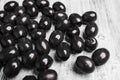 Black olives on a white wooden background