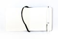 Black open small notepad, white pen lie in unfold notebook, note with blank empty light pages. White backdrop Royalty Free Stock Photo