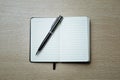 Black opened notebook and pen on the table on left top view. Royalty Free Stock Photo