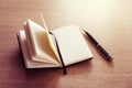 Black opened notebook and pen on the table on left top view. Royalty Free Stock Photo