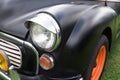 Black and orange front of vintage cars on the grass