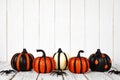 Black and orange glittery Halloween pumpkins against white wood Royalty Free Stock Photo
