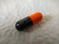 Black and orange pills on a white napkin close-up Royalty Free Stock Photo