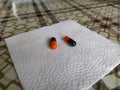 Black and orange pills on a white napkin close-up Royalty Free Stock Photo