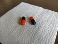 Black and orange pills on a white napkin close-up Royalty Free Stock Photo