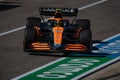 Black and orange race car on the track during Formula 1 racing competition in Austin, Texas