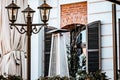 Black outdoor light fixture hangs from the front of a white house. Royalty Free Stock Photo