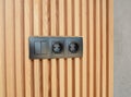 Black outlet plug on the modern wooden house wall. Socket and european power.