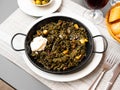 Black paella with cuttlefish ink and seafood in black pan in Spanish restaurant. Traditional dish of Spanish cuisine Royalty Free Stock Photo