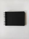 Black paged notebook on white surface. Artistic, education, school