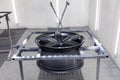 A black painted aluminum alloy wheel is mounted on a special frame during drying in a chamber in a vehicle body repair workshop. Royalty Free Stock Photo