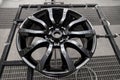 A black painted aluminum alloy wheel is mounted on a special frame during drying in a chamber in a vehicle body repair workshop. Royalty Free Stock Photo