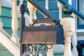 Black painted decorative mail box near front door with stairway and white banister or gaurd rails and green steps on Royalty Free Stock Photo