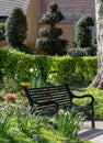 Black painted garden bench photographed in springtime at Eastcote House historic walled garden, Hillingdon UK Royalty Free Stock Photo