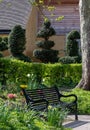 Black painted garden bench photographed in springtime at Eastcote House historic walled garden, Hillingdon UK Royalty Free Stock Photo