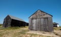 Black painted wooden fishermens` huts in the sand dunes at Winterton on Sea near Great Yarmouth on the east coast of Norfolk UK. Royalty Free Stock Photo