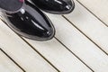 Black pair rubber galoshes stand on white wooden background