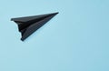 Black paper airplane on blue background