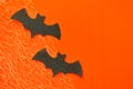 Black paper bats lie on orange background with cobwebs