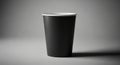 Black paper cup with a white interior on a gray background. The cup has a smooth Royalty Free Stock Photo