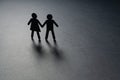 Black paper figure of a couple holding hands on gray surface. Loneliness, childless, old age concept. Royalty Free Stock Photo