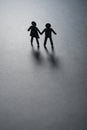 Black paper figure of a couple holding hands on gray surface. Loneliness, childless, old age concept. Royalty Free Stock Photo