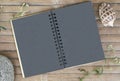 Black paper notebook on rustic wooden background with natural decor. Royalty Free Stock Photo
