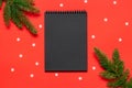 Black paper notepad with spruce branches and snowflakes