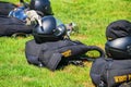 Black paratrooper helmet on parachute knapsack on the grass. There is a white glove on the helmet