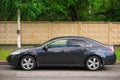 A black parked car along the road in the city.