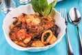 Black pasta with shrimps, crab meat, seafood, squid rings, basil, greens and cheese. Royalty Free Stock Photo