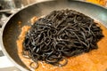 Black pasta squid ink in a pan - italian taglierini al nero di seppia Royalty Free Stock Photo