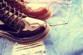 Black patent leather boots on ragged jisas close-up.