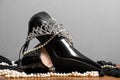 Black patent leather women`s shoes, pearls and diadem on the table
