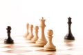 black pawn on a chessboard with white chess pieces Royalty Free Stock Photo