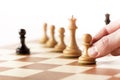 Black pawn on a chessboard with white chess pieces Royalty Free Stock Photo