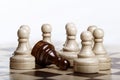 Black pawn lying on chessboard among many white chess figures Royalty Free Stock Photo