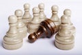 Black pawn lying on white surface among many white chess figures Royalty Free Stock Photo