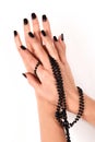 Elegance Refined: Black Pearls Necklace Adorns Female Hand with Stylish Black Nail Polish on White Background Royalty Free Stock Photo