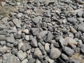 Black pebbles scattered on the side of a highway.