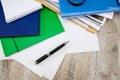 Black pen, colored folders for documents, envelopes, notebooks, stationery on the background of the desktop. View from above.